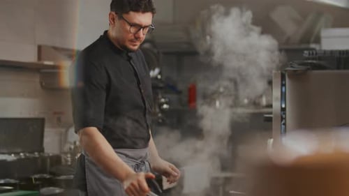 Chef Igniting Flame in Pan and Cooking Food in Restaurant Kitchen