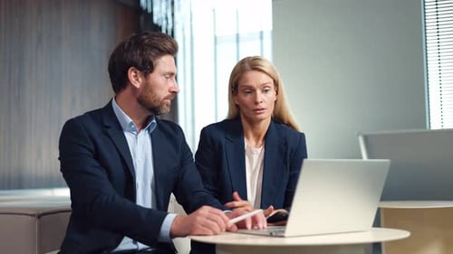 Business Professionals Collaborating on Laptop in Office