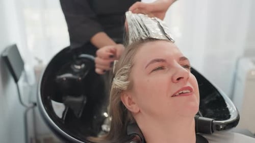 Woman Getting Hair Highlighted at Salon Sink