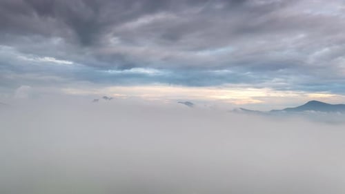 Luftaufnahme Morgenlandschaft Nebel, der über den hohen Bergen fließt.