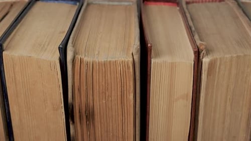 Closeup View of Old Hardcover Books Aligned in Vertical Stack Formation