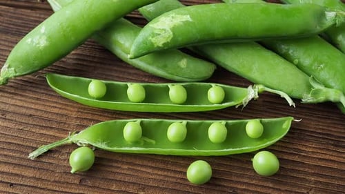 Fresh pea pods on a wooden background
