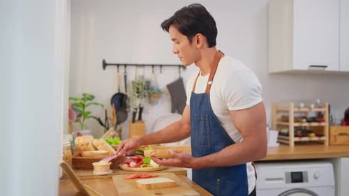 Attractive Man Making Sandwich in Modern Kitchen
