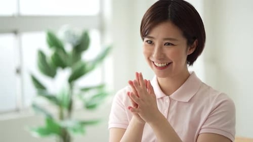 Smiling Woman Claps Hands Together Indoors