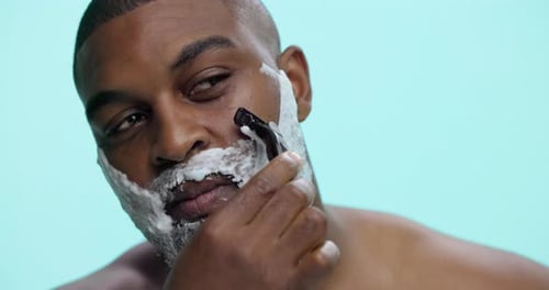 Razor, shaving and man with cream, beard and routine for hygiene in studio and facial treatment