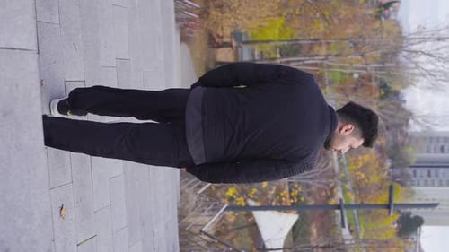 Vertical Video of Depressed man walking in the city center. Despair and dissatisfaction.