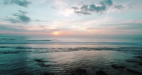 Peaceful Golden Sunset Over Calming Ocean Waves Along The Shore
