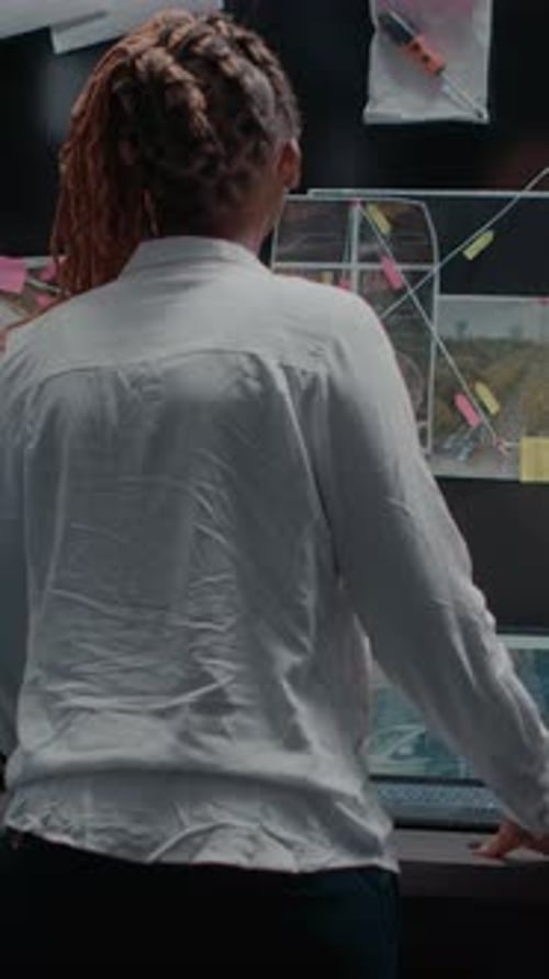 Detective Looking at Crime Scene Board in Office