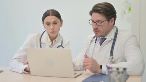 Doctors Discussing on Laptop in Office Setting