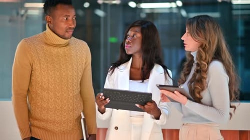 Multiracial group of people in an office discussing business using tablets