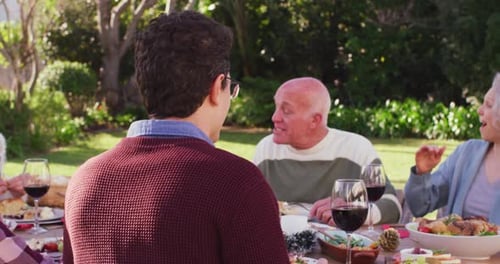 Portrait of happy caucasian family having dinner in garden