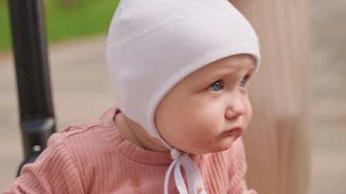Infant Tasting Food Outdoors Closeup Of Infant Exploring Snack During Outdoor Walk Baby In White Hat