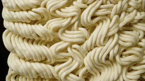 Dry pressed noodles. Rotates on a black background, close-up