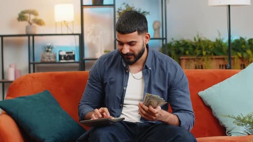 Rich Happy Indian Man Using Calculator Counting Money Cash Salary Calculate Domestic Bills at Home