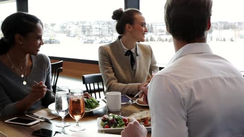 Happy business team laughing and enjoying working lunch together in restaurant