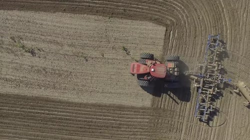 Big red combine working on the field cultivating and applying nitrogen ASP