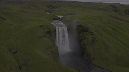 Aerial View of Majestic Waterfall and Green Landscape
