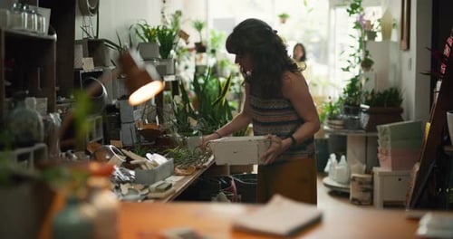 Female Store Owner and Assistant Taking Care of Plants in Interior Boutique