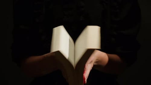 Book Closes with Dust Puff on Black Background