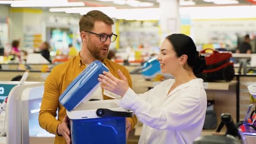 Young Couple Buying Portable Refrigerator for Car in Appliances Store