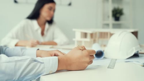 Architects Collaborating on Blueprints in Modern Office