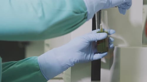 El asistente fija el tubo con líquido naranja en la herramienta