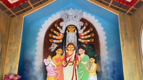 La caméra se déplace vers l'arrière pour capturer un magnifique mannequin de Durga et un pandal de Dura Puja (temple temporaire fabriqué à cette fin)