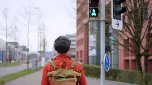 Mochileiro asiático atraente andando por uma bela estrada na cidade.