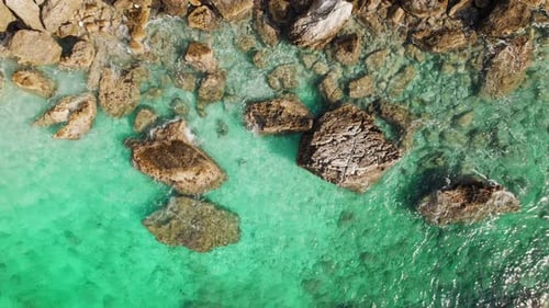 Top down view of rocks in clear turquoise shallow sea water