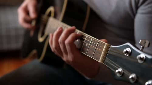 Man Plays Black Acoustic Guitar Close Up