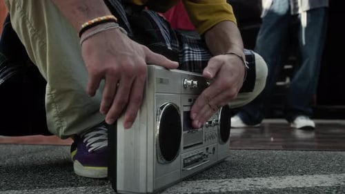 Unrecognizable Rapper Loading Cassette into Silver Retro Boombox