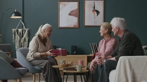 Senior Women Give Gift to Man in Living Room