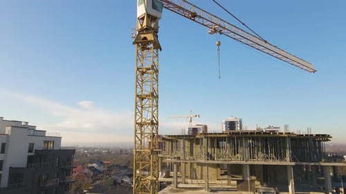 Vista aérea de grúas de torre alta y edificios de apartamentos residenciales en construcción