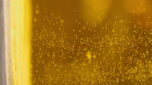 Extreme Close up of craft Beer bubbles floating to the top of a pint glass VERTICAL