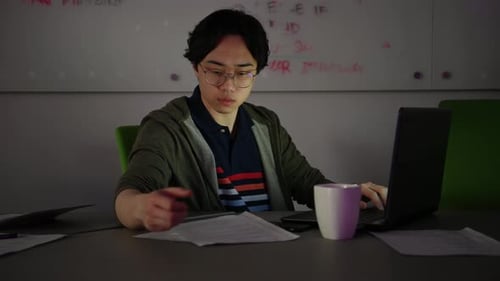 Young Man Working on Laptop in Office