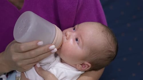 Loving Infant Being Bottle Fed Indoors