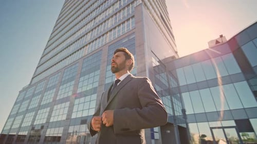 Man Buttons Suit Jacket Near Glass Office Building