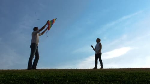 Father and Daughter Flying Kite on Open Field at Sunset, Steadicam