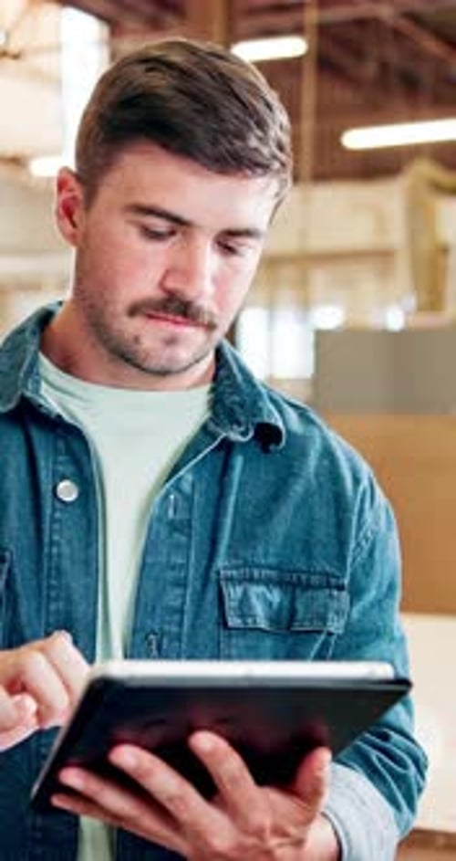 Man, carpenter and research with tablet for inventory, checklist or maintenance in workshop