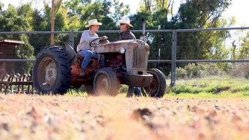 Teen and Adult on Antique Tractor