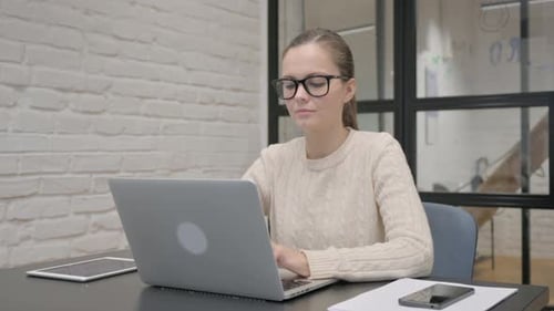 Woman Working on Laptop in Office Smiling