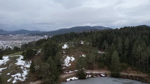 Snowy Village With Dense Forest At Wintertime