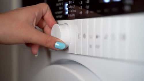 Young woman setting the washing machine 4K