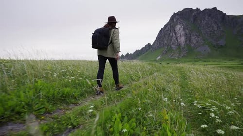 Traveler Girl Dressed in a Hat a Green Jacket and Backpack She Walks Along the Coast of the