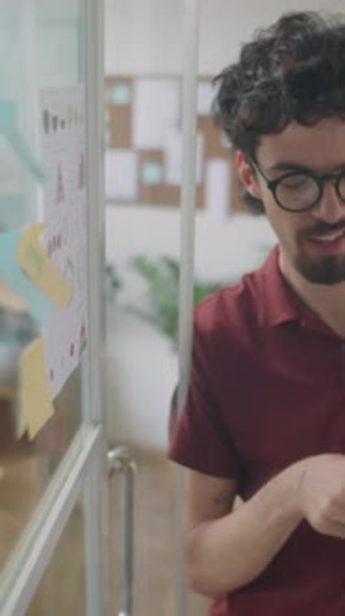 Homme expliquant les tâches professionnelles sur des notes autocollantes à un collègue
