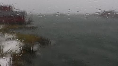 Raindrops On Window. The view of a Norwegian fjord from behind a window on a windy rainy day. Lofote