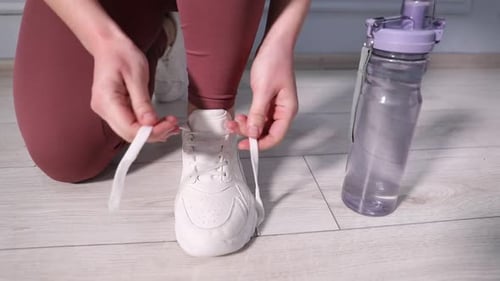 Woman Tying Athletic Shoe Laces Before Workout