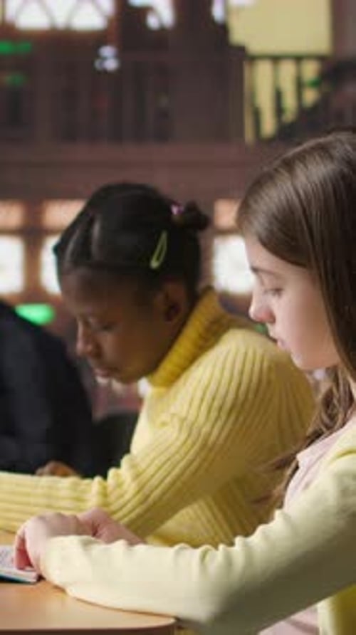 Vertical Video Teen Girls Reading Books in the Library to Focus on Mandatory Literature