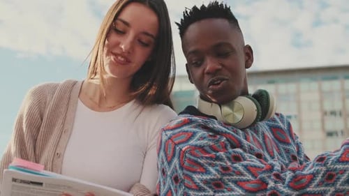 Close up, student couple studying while sitting outside the university