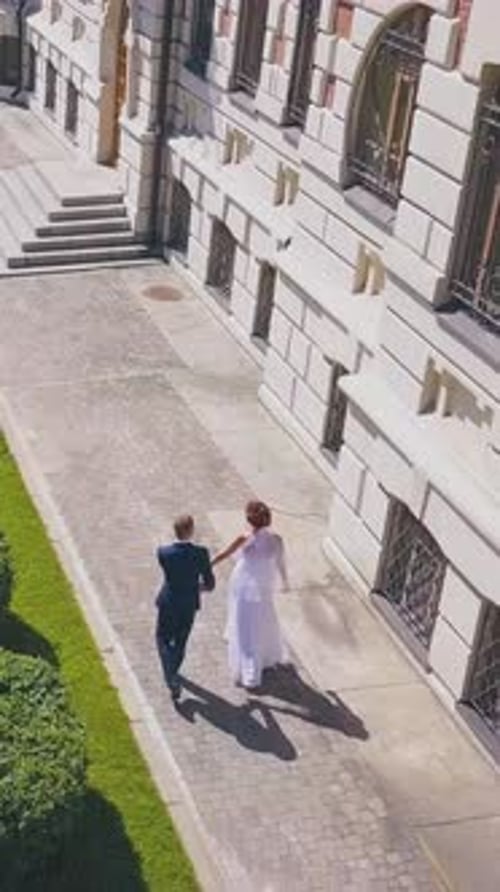 Bride Spins Walking with Groom in Street Aerial View